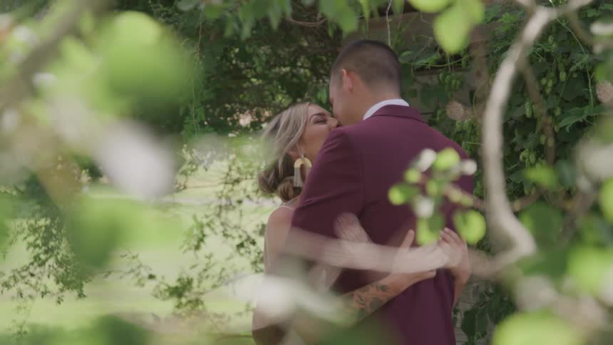 Bride and groom hold and kiss each other in the public park