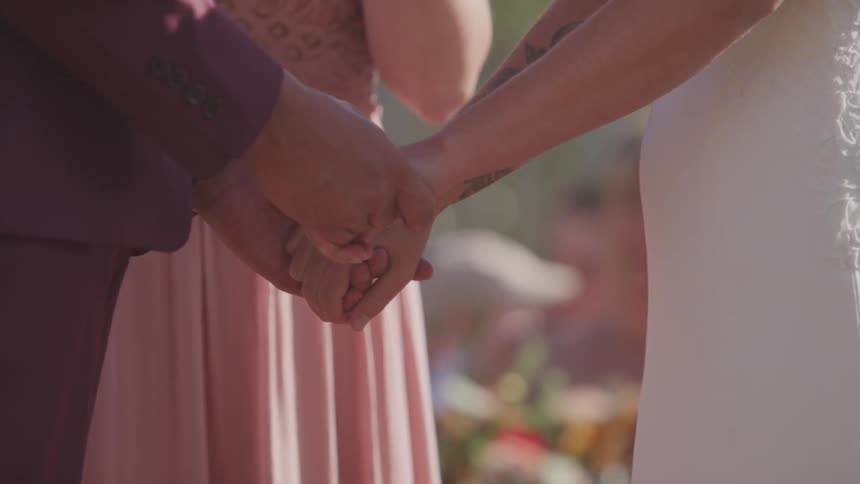 Couple holding hands at wedding