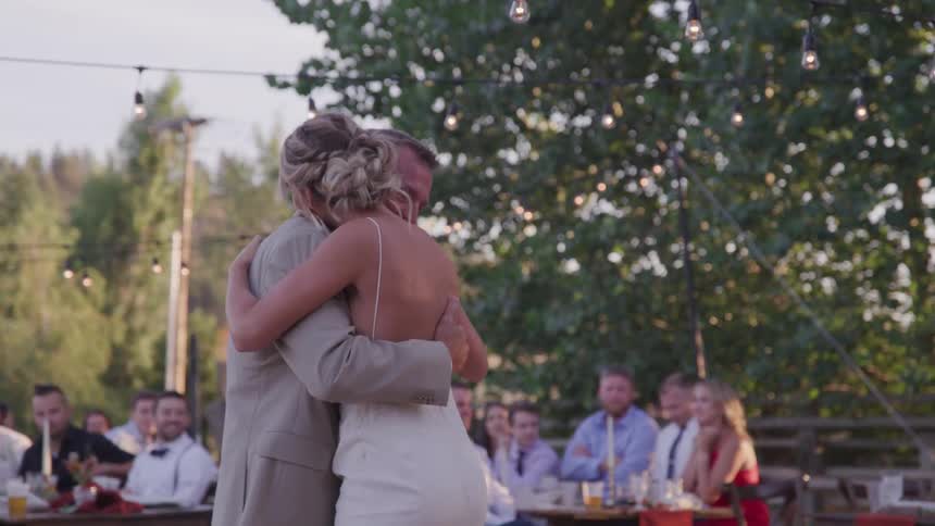 A man and a woman hug on a dance floor of a wedding