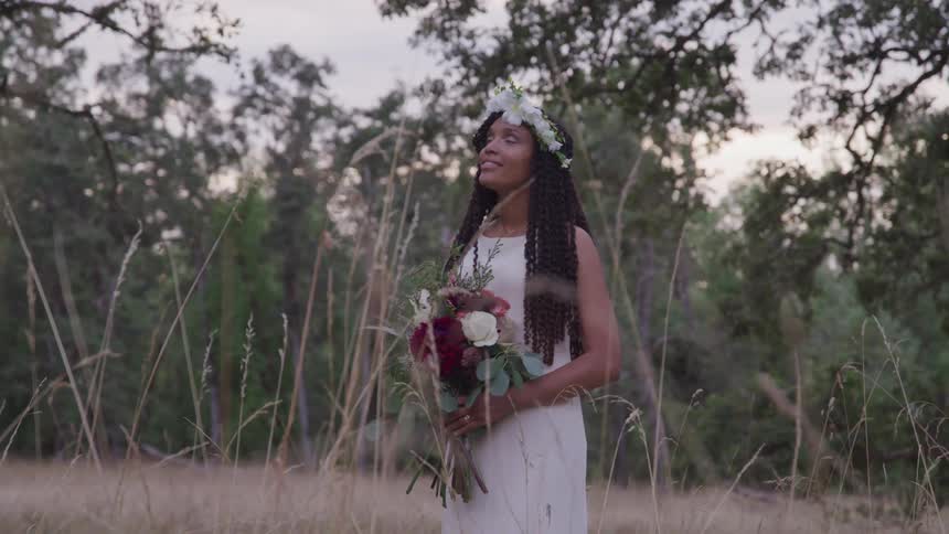 Beautiful bride posing with bouquet outdoors in the forest