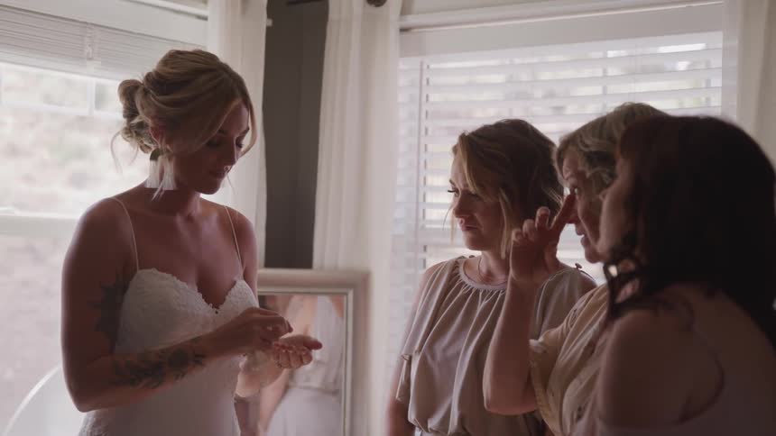 A bride preparing before wedding with her friend