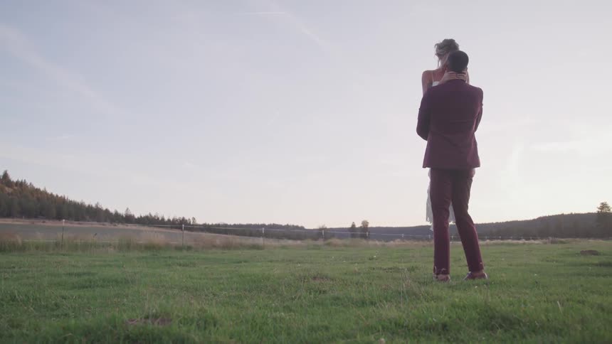 A couple hugging at the grassland