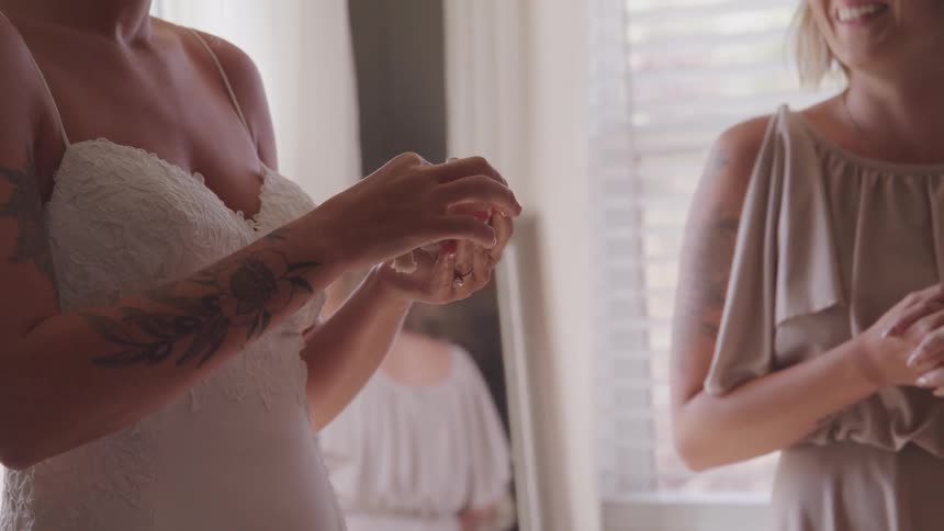 Women are standing in a room wearing dresses