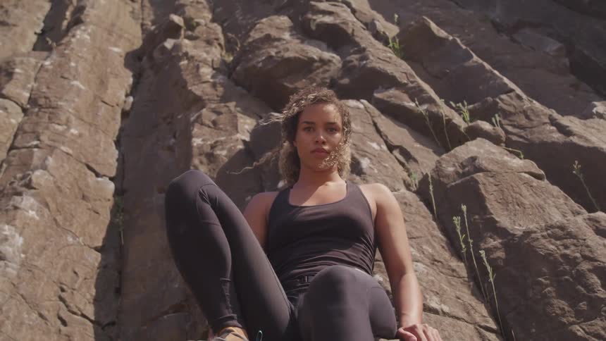 A young woman sits on a cliff