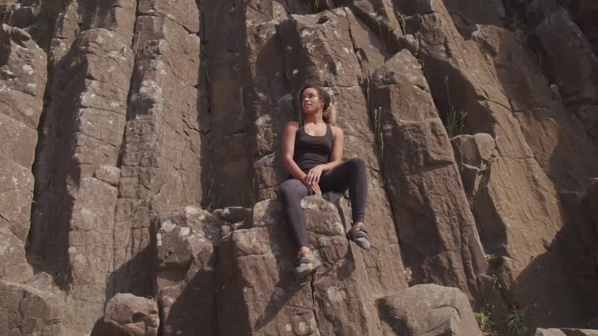 A woman sitting on a rock