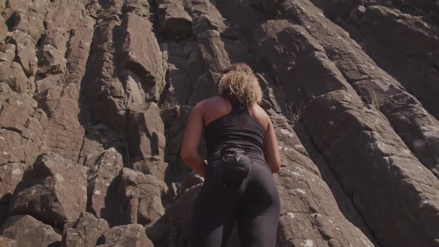 A woman contemplates climbing