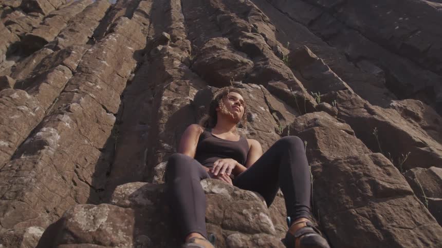 Rock climber sitting on mountain cliff
