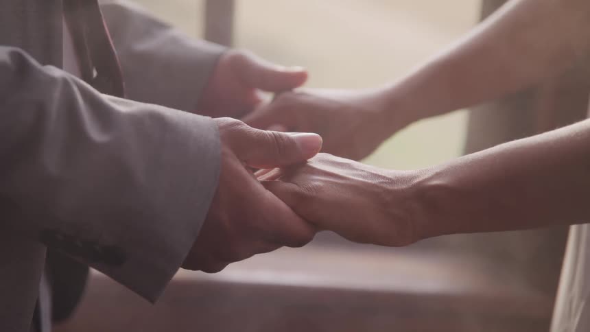 Wedding couple holding hands during ceremony