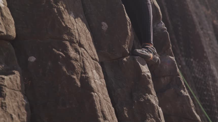 A footage of a foot on a rock climbing