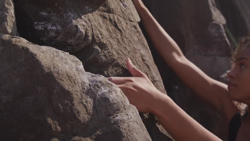A person grabs onto a rock while climbing