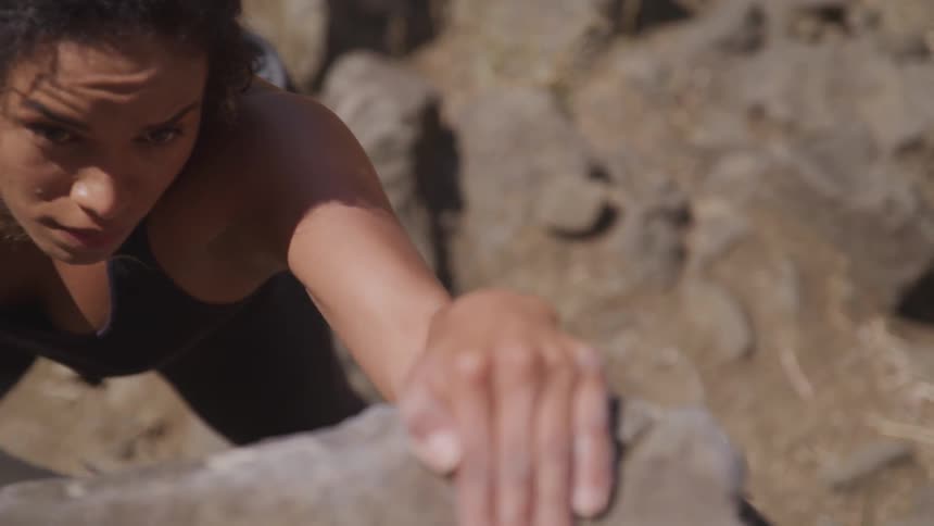 A woman climbing rocks outdoors during the day