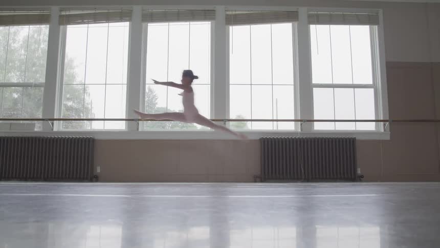 Little ballerina runs and jumps in the ballet studio