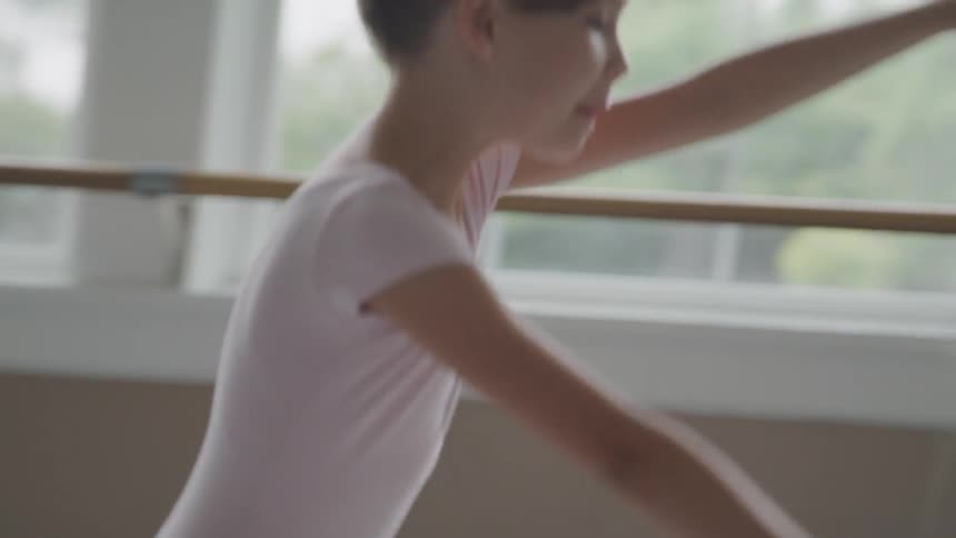 A child is doing ballet in a room