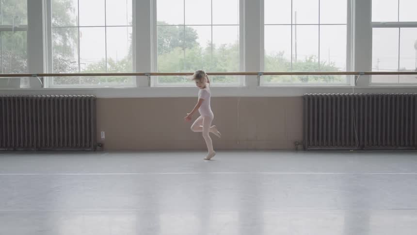 A little girl spins in a circle as she does ballet