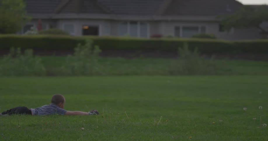 A boy in a gray shirt catches a ball