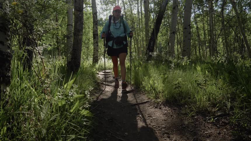 Man and woman hike in the woods during the day