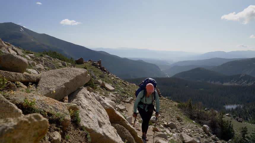 Hikers walk through a rocky terrain