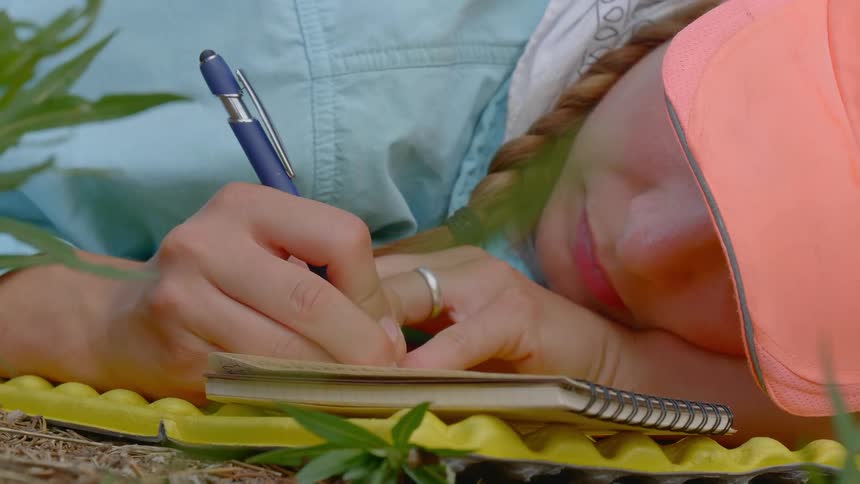 A woman writing on her notebook