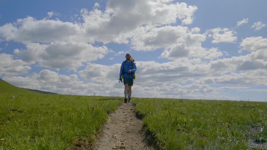 A man hikes down a narrow path