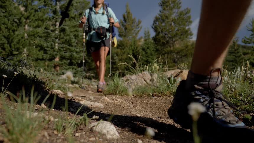 A man and woman hike along a gravel path