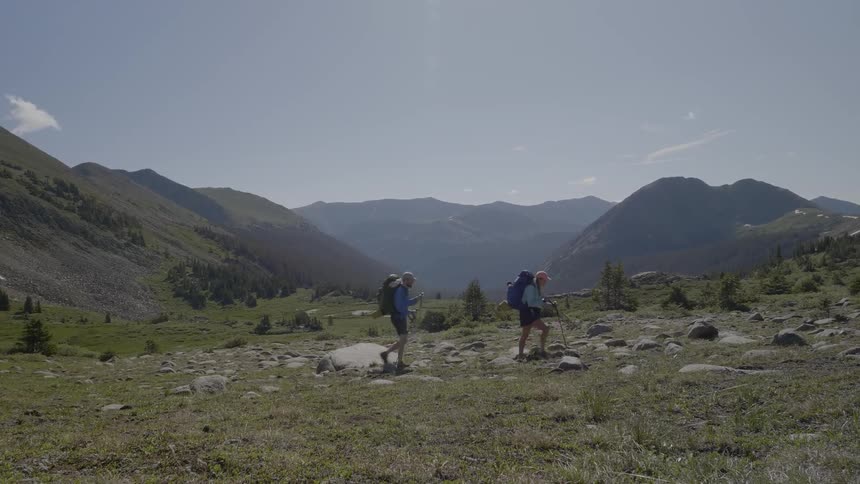 Two people are hiking together uphill