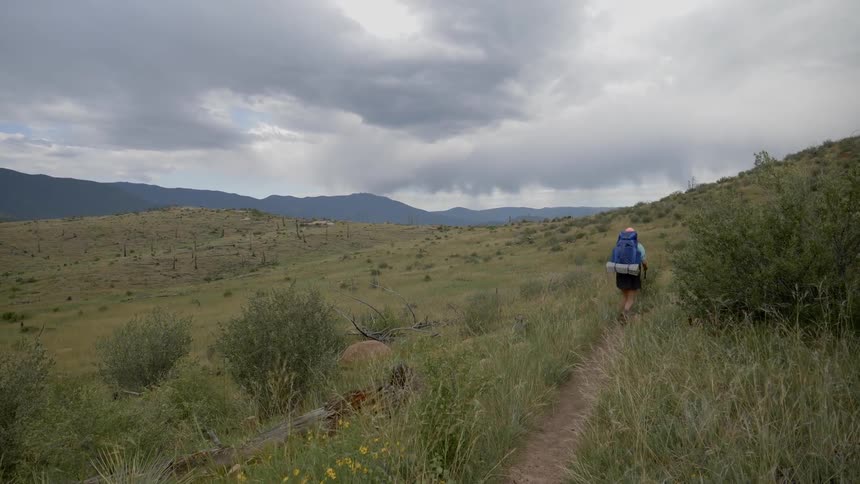 A person hiking along a path through an open terrain