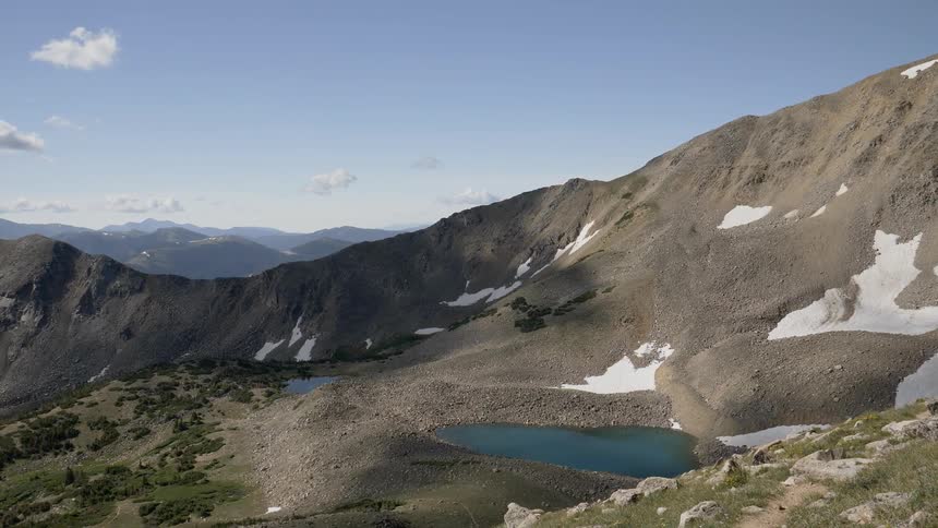 A sprawling mountain range stands calmly underneath a clear blue sky