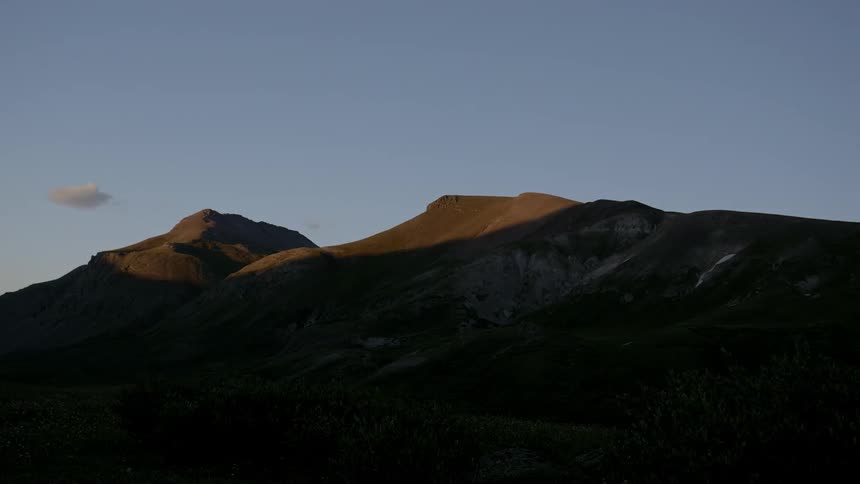 Day turns to night as the sun sets on a mountain range