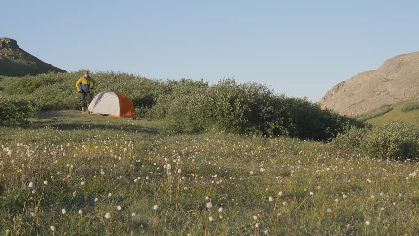 A man camping at a grass land