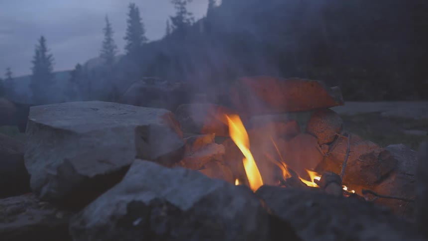 A fire burns in a stone fire pit