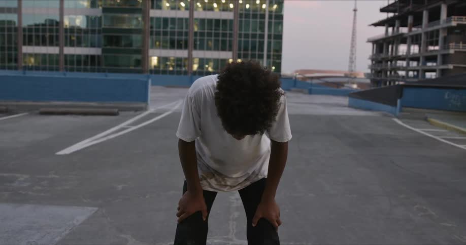 A boy is bent over himself from exhaustion