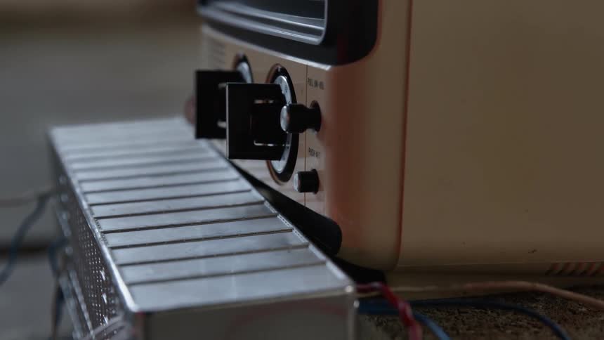 Wires go in and out of equipment with dials and a monitor