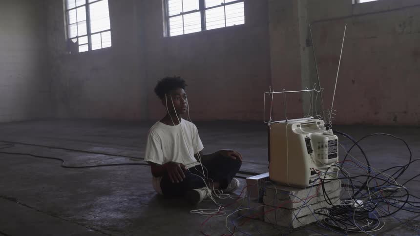 A black boy running in an empty warehouse