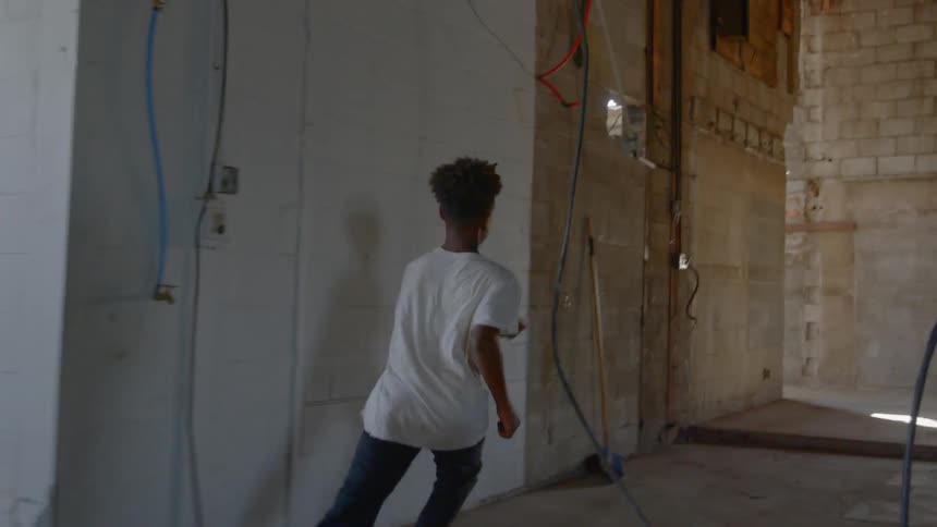 A young boy runs in an empty building