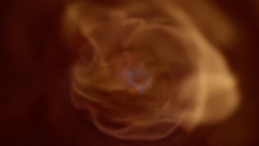 A burst of flame fills a confined tubular space with fire and smoke