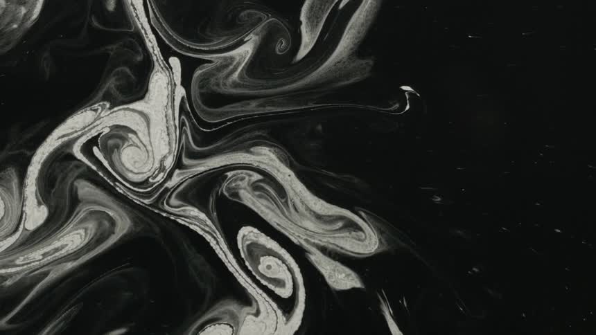 White and black liquids swirl together
