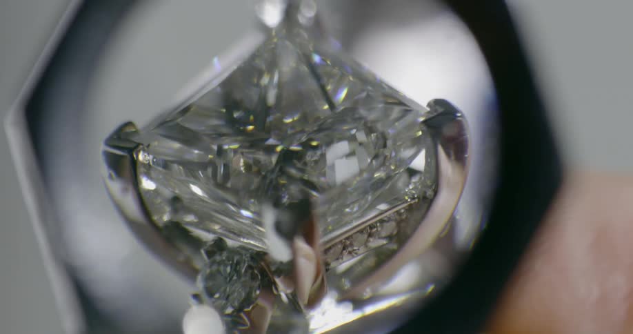 A diamond ring being viewed through a magnifier