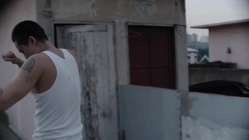 A man practicing boxing on a roof
