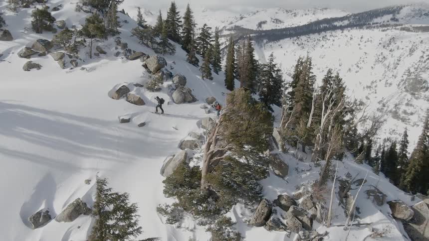 Two people cross country ski on the top of a mountain