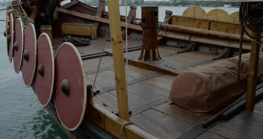 An old wooden battleship with shields mounted over the side
