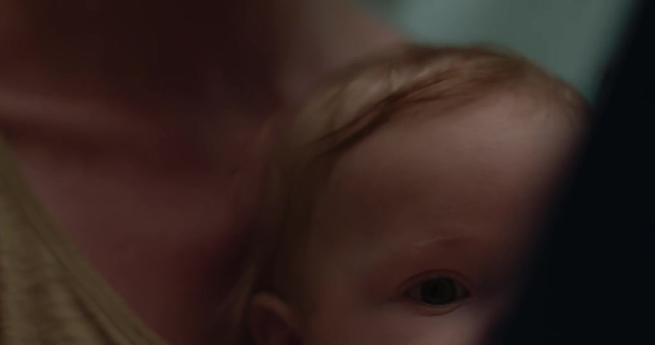 A woman holds a baby on her lap