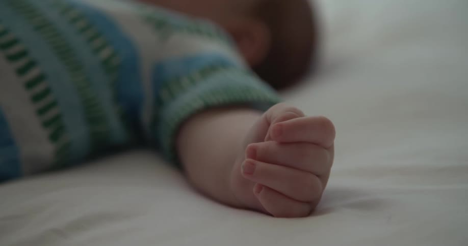 A baby lays on a bed