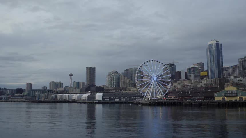 A ferris wheel stands amidst a cityscape