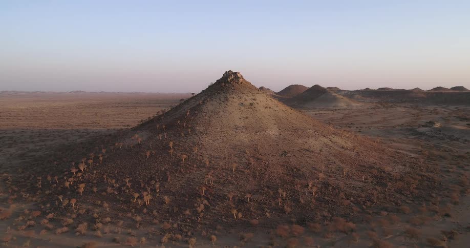 Rocky hills stand in the midst of a flat and desolate area