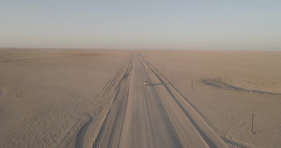 A car driving down a dusty road