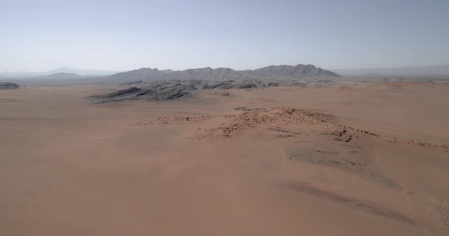 A large desert leading towards a mountain range