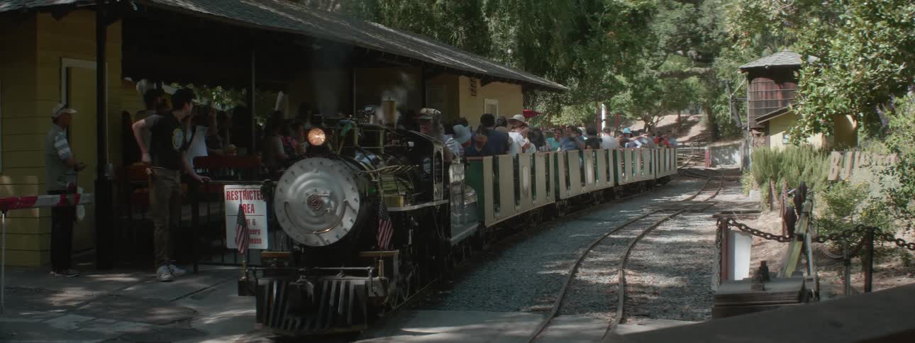 Amusement train park arriving at station with passengers