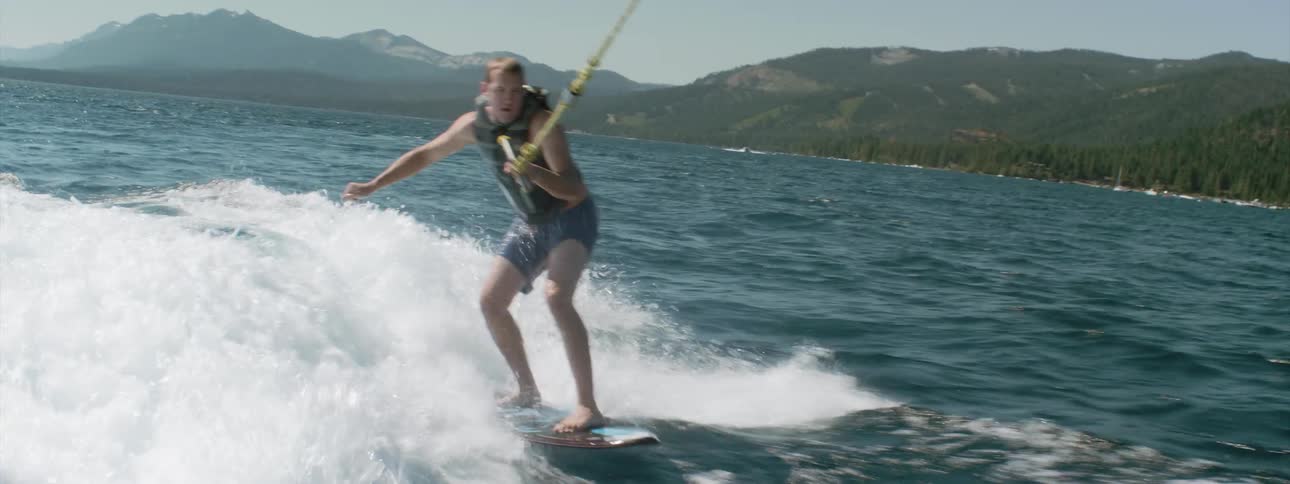 A young boy is water skiing and falls