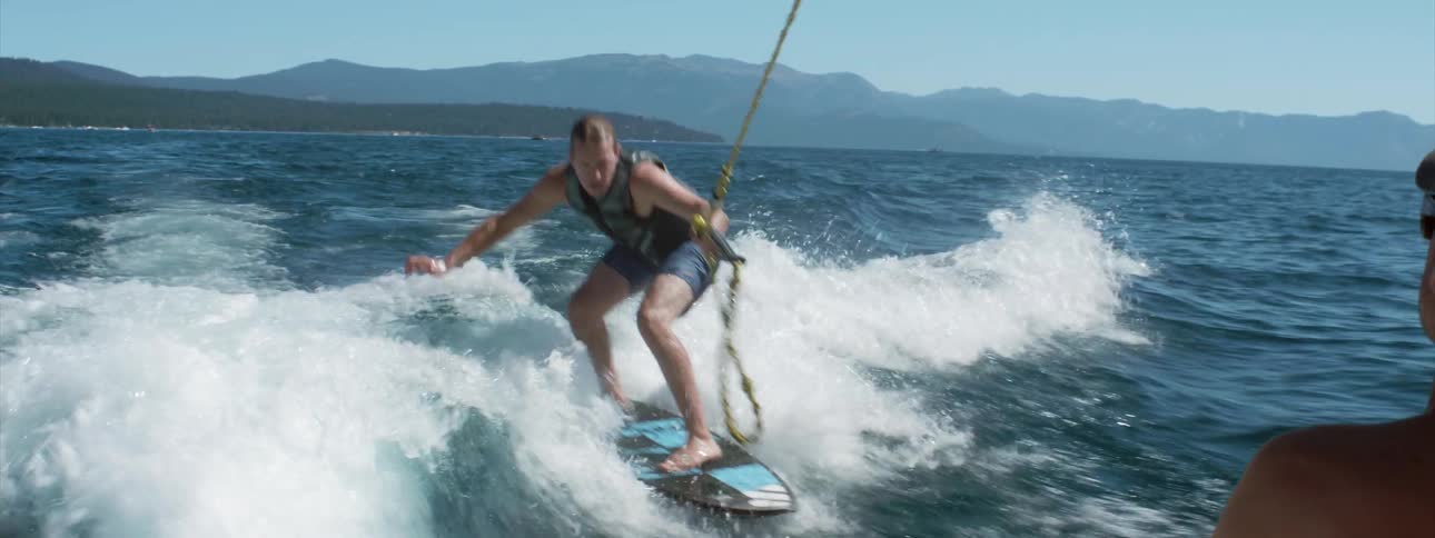 A man riding a wakeboard behind a boat
