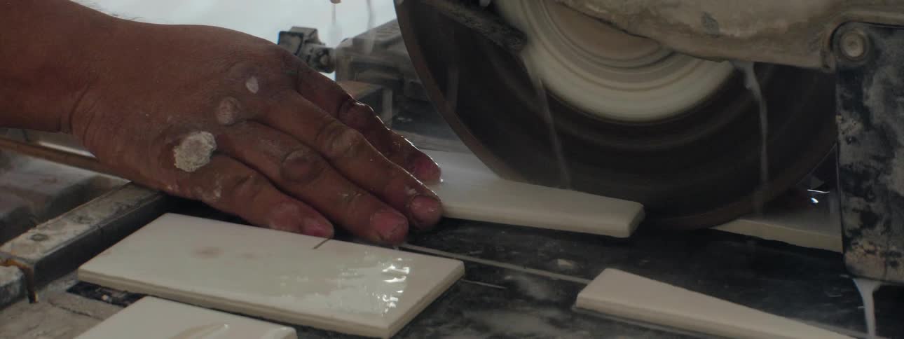 A man uses a table saw to cut pieces of wood